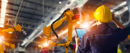 Sanayi robotlarıyla çalışan teknisyen resmi.